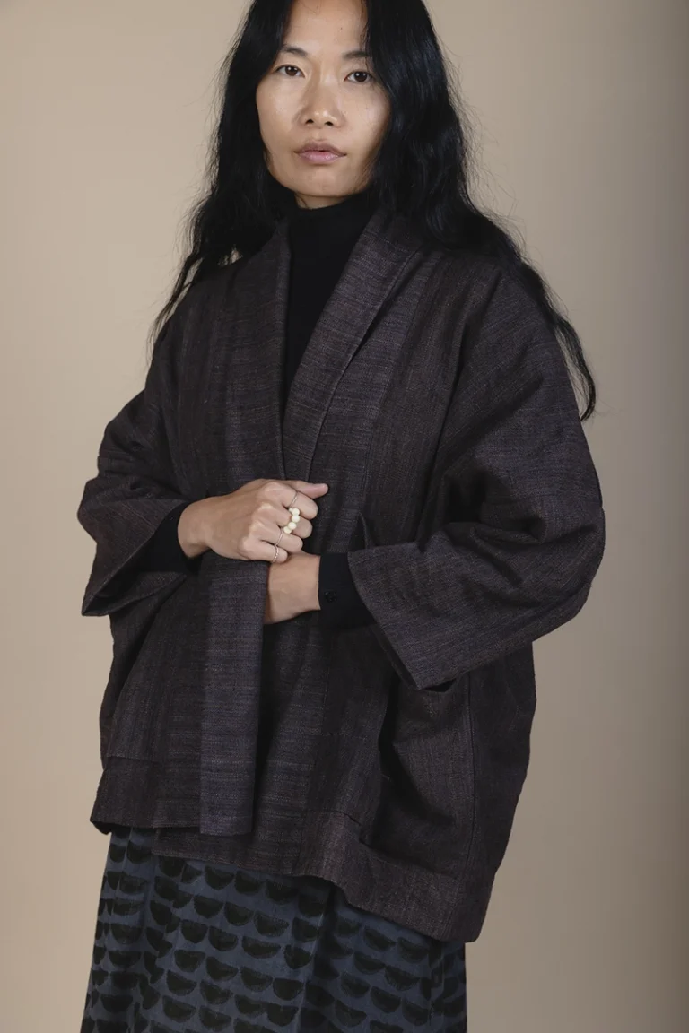 woman with long black hair wearing brown jacket