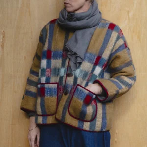 woman wearing red and camel blanket jacket
