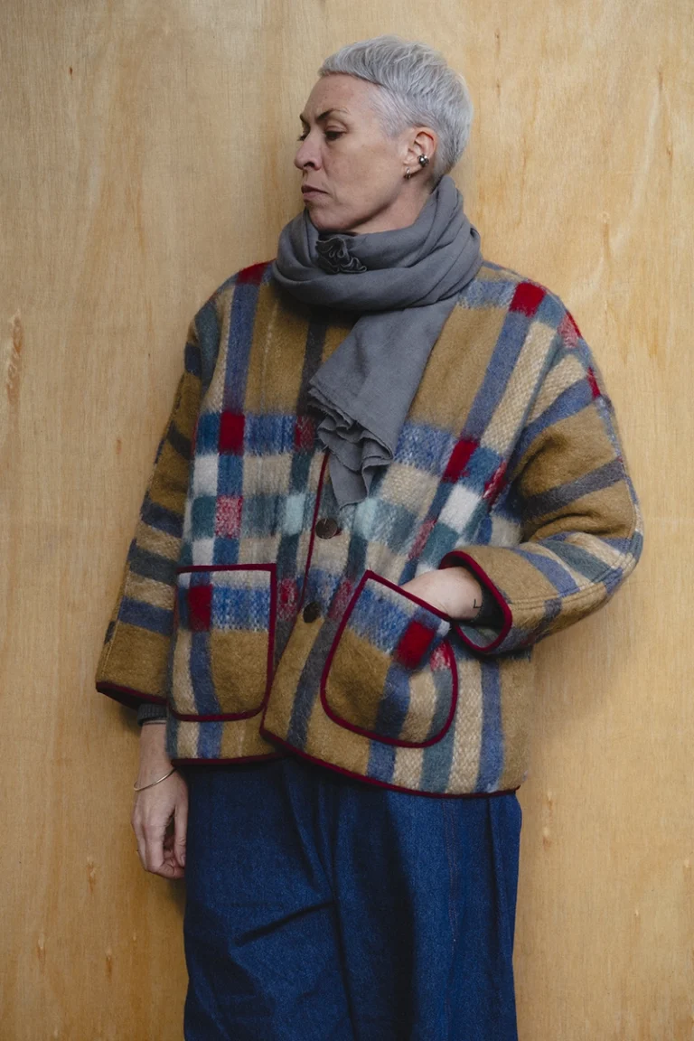 woman wearing red and camel blanket jacket