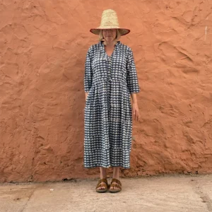 Woman wearing the Romani indigo Dabu block print button front dress with adjustable drawstring waist.