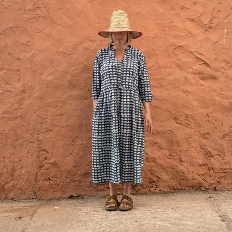 Woman wearing the Romani indigo Dabu block print button front dress with adjustable drawstring waist.