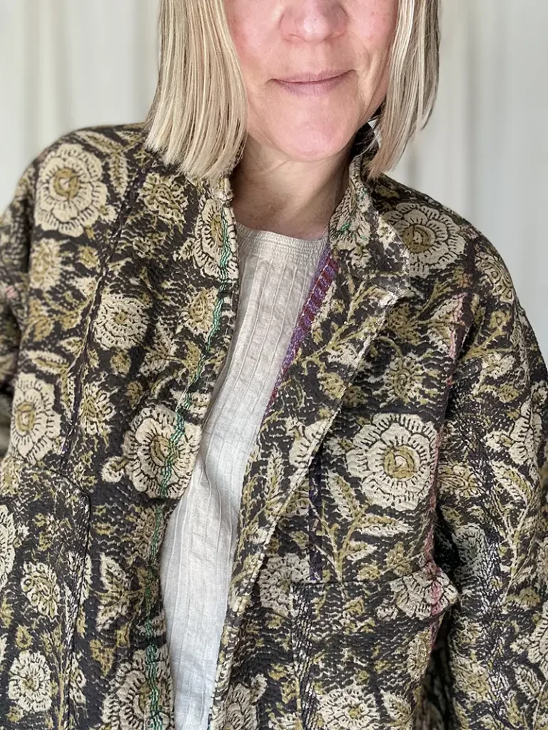 zoom in of woman wearing black floral kantha jacket
