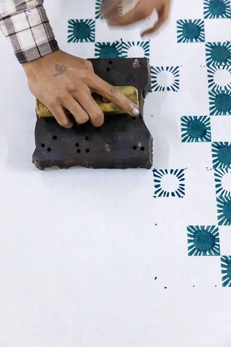 Rhythmic Sunray motif being block printed by hand in a small-batch workshop.