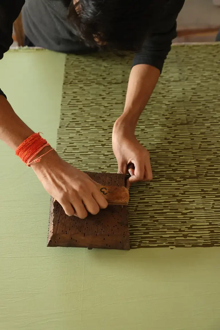 Close-up of wooden block printing technique used to create the camo motif on summer-weight cotton.