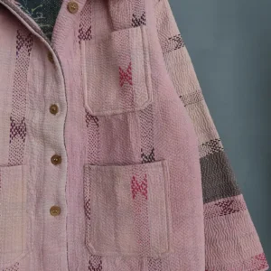 Close-up of pale pink hand-stitched kantha embroidery on a vintage cotton chore jacket.