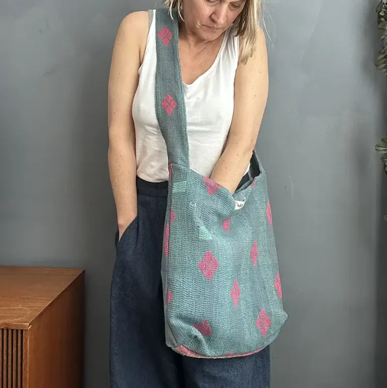 woman wearing a green kantha stitched boho sling bag