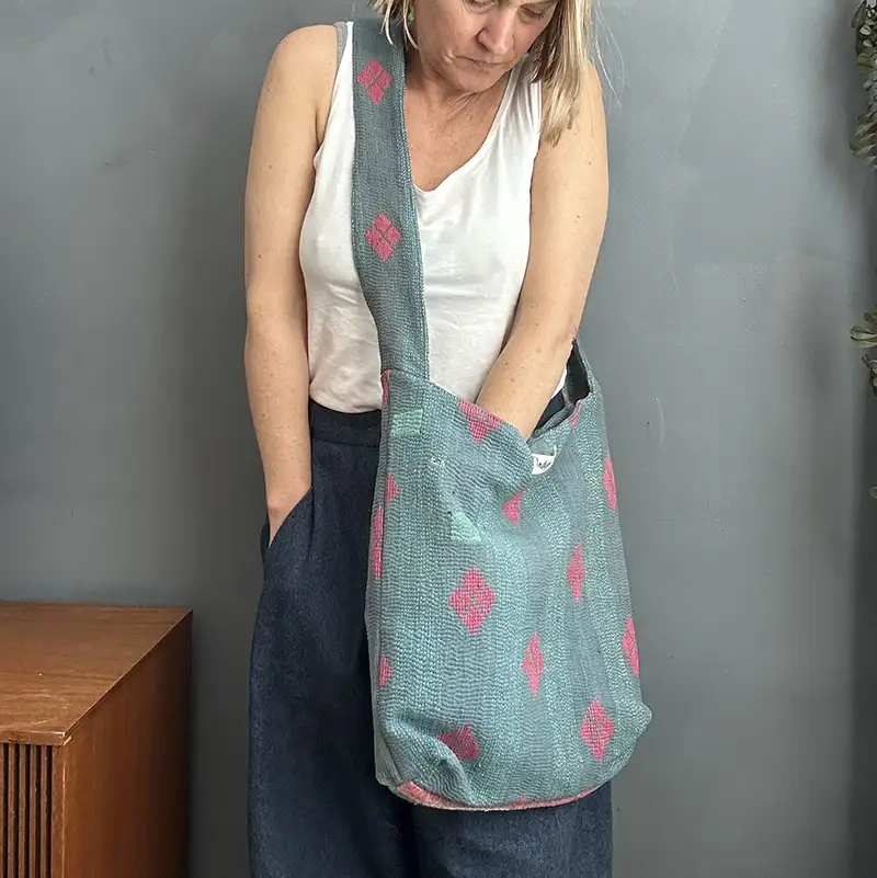 woman wearing a green kantha stitched boho sling bag