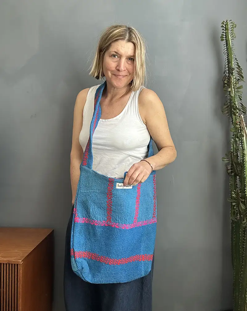woman wearing a bright blue kantha stitched boho sling bag