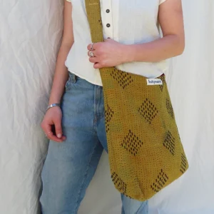 woman wearing yellow kantha fabric sling bag