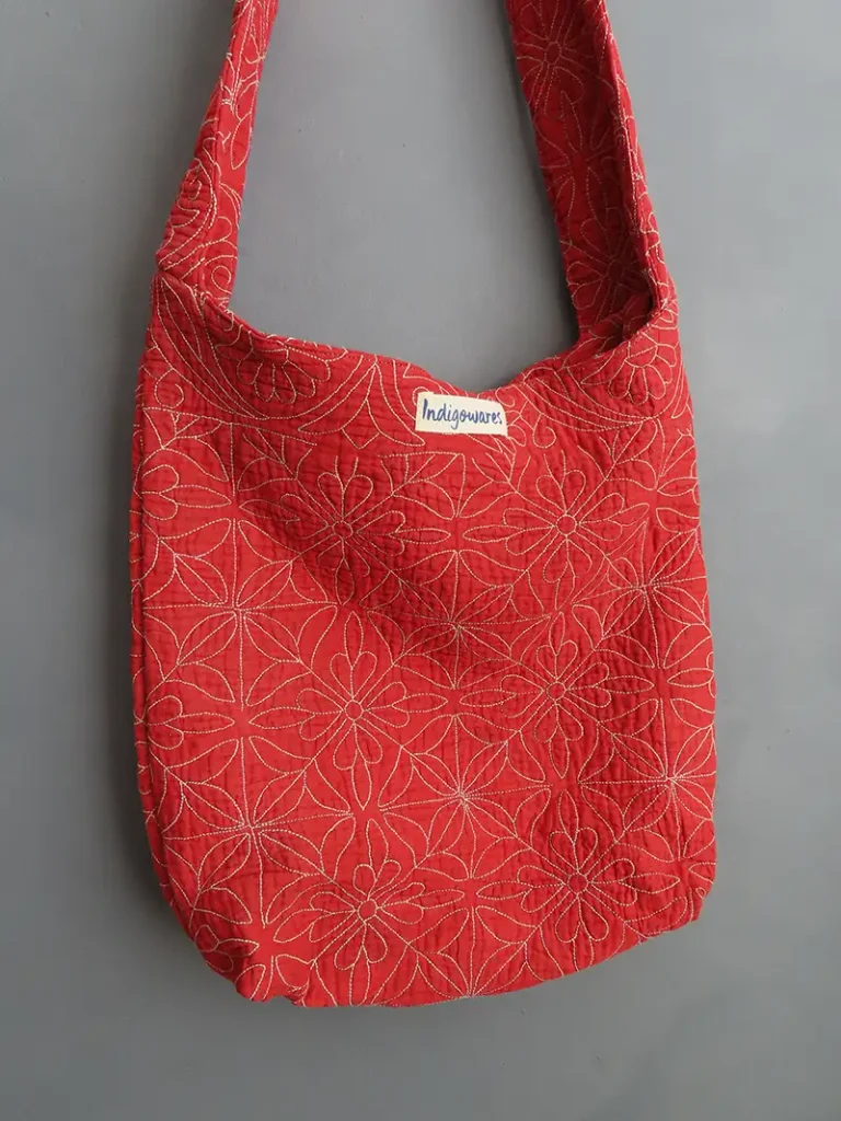Close-up of traditional hand-stitched kantha embroidery on a sustainable crossbody bag.