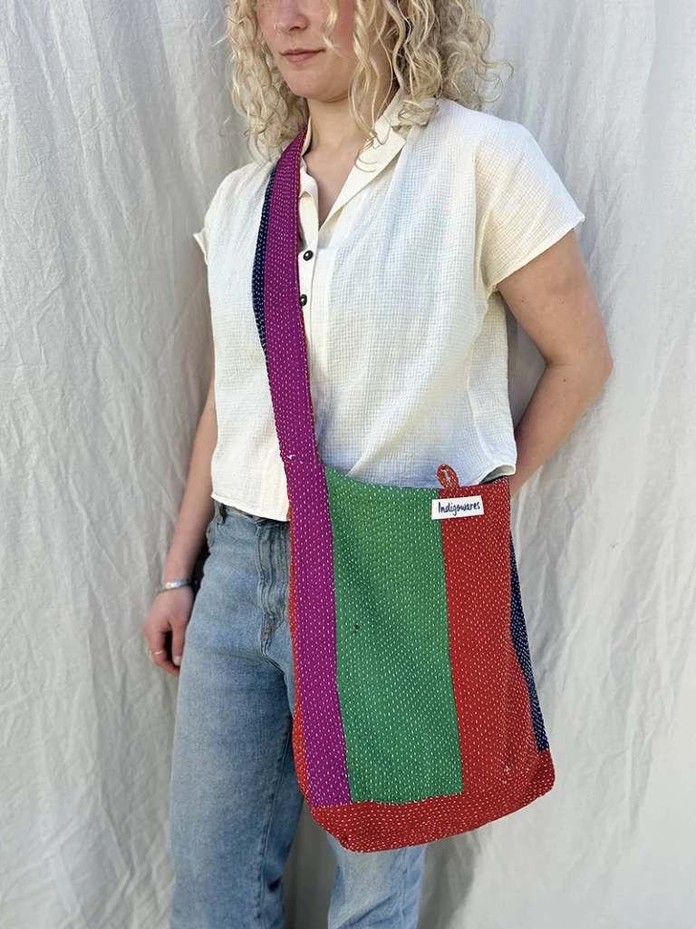 woman wearing green,red,purple and pink crossbody kantha embroidery fabric bag