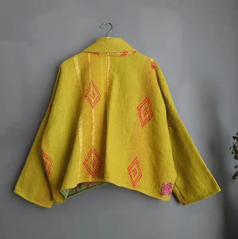 back view of kantha fabric jacket hanging on a wall