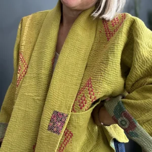 close up view of woman in yellow kantha jacket