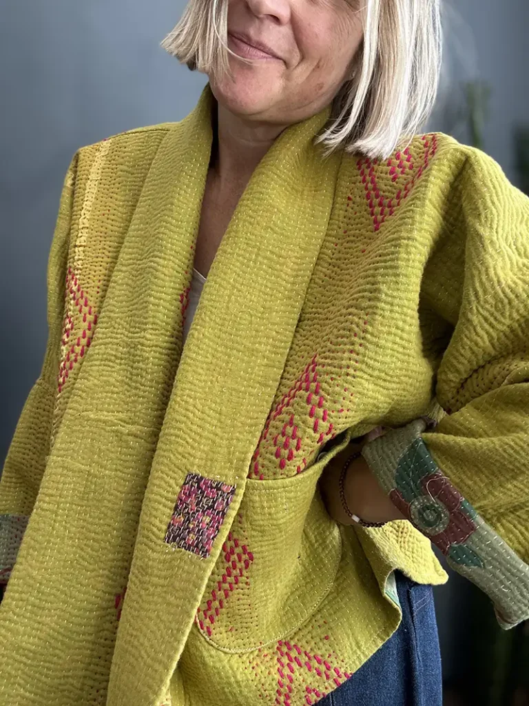 close up view of woman in yellow kantha jacket