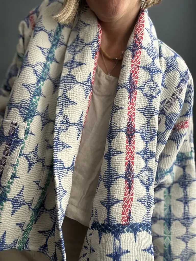 woman wearing a blue and white short kantha jacket