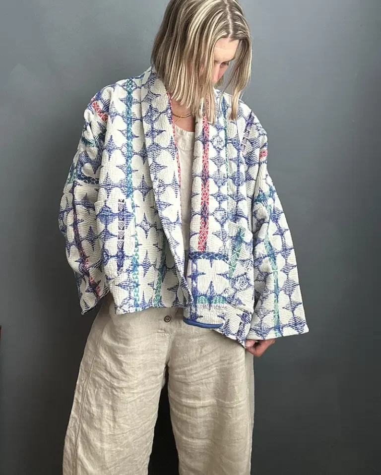 woman wearing a blue and white short kantha jacket