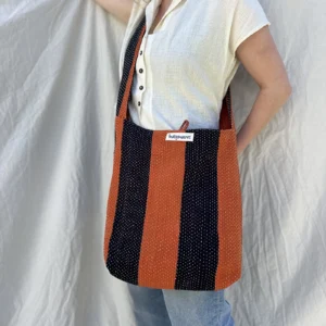 woman wearing striped fabric cross body bag
