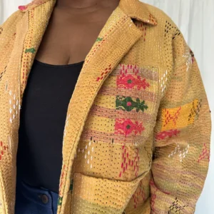 zoom in detail woman wearing a golden yellow kantha chore jacket