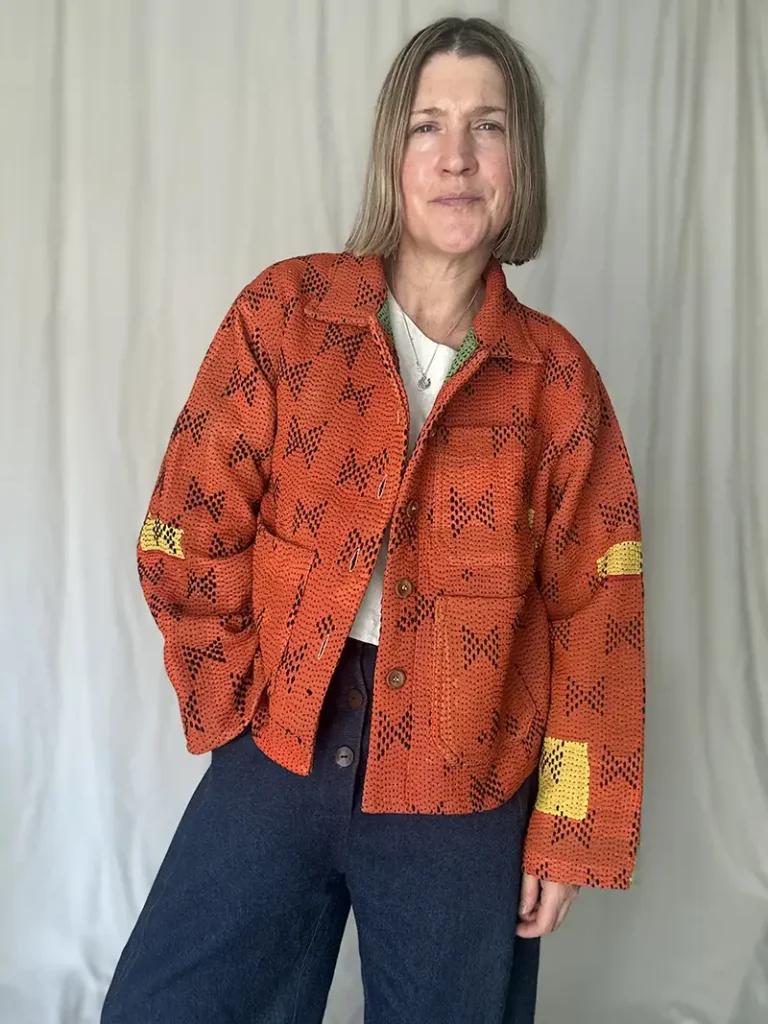 woman wearing a short orange kantha jacket with buttons