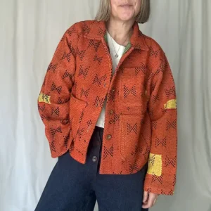 woman wearing a bright orange kantha stitched chore jacket