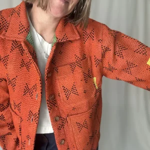 zoom in of woman wearing an orange kantha chore jacket