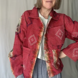 zoom in woman wearing bright red kantha chore jacket
