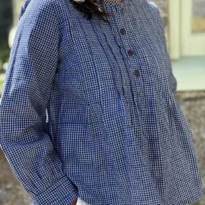 woman wearing artisan pintuck blouse with white shorts