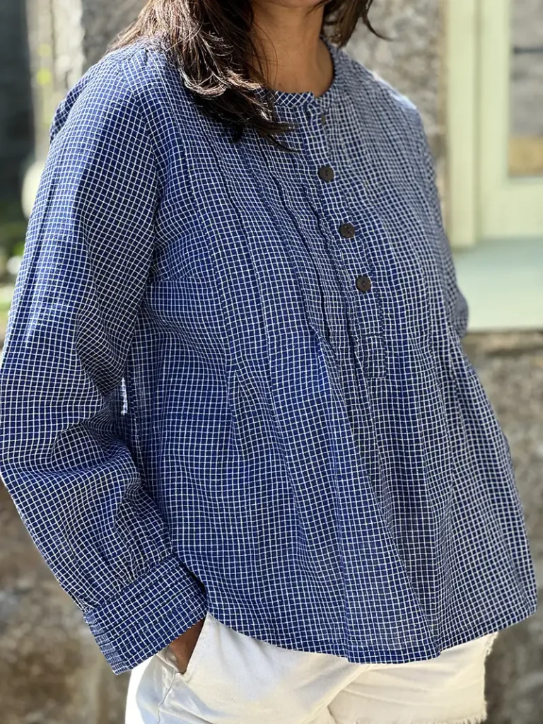 woman wearing artisan pintuck blouse with white shorts