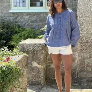 woman wearing artisan pintuck blouse with white shorts