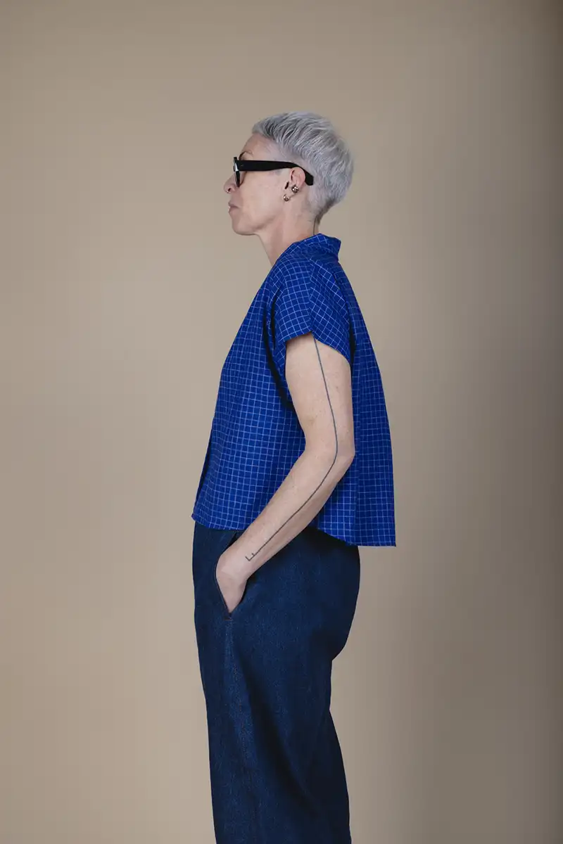 woman with grey hair wearing a short sleeve blue shirt