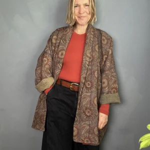 long indian kantha jacket worn with a burnt orange sweater