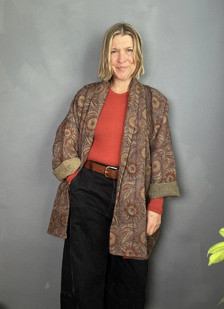 long indian kantha jacket worn with a burnt orange sweater