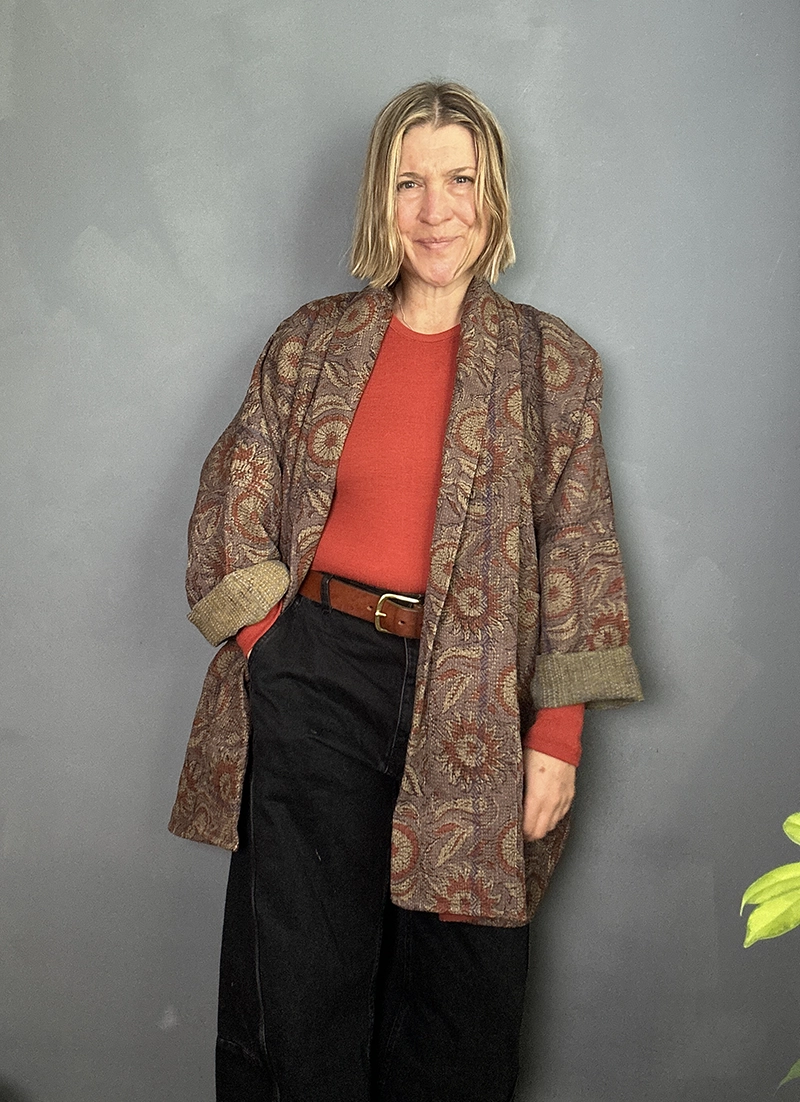 long indian kantha jacket worn with a burnt orange sweater