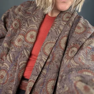 zoom in woman wearing a vintage indian kantha jacket in dark tones