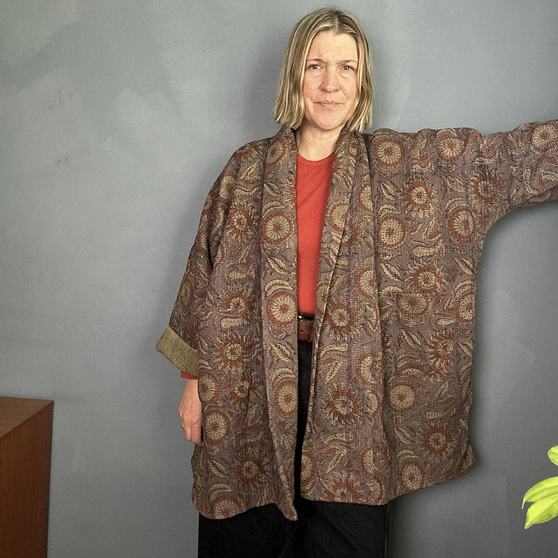 woman wearing a vintage indian kantha jacket in dark tones