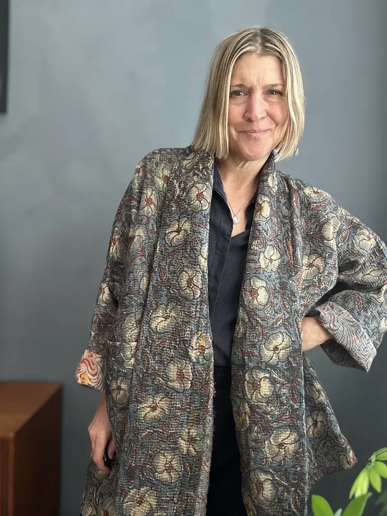 woman wearinga long dark kantha jacket
