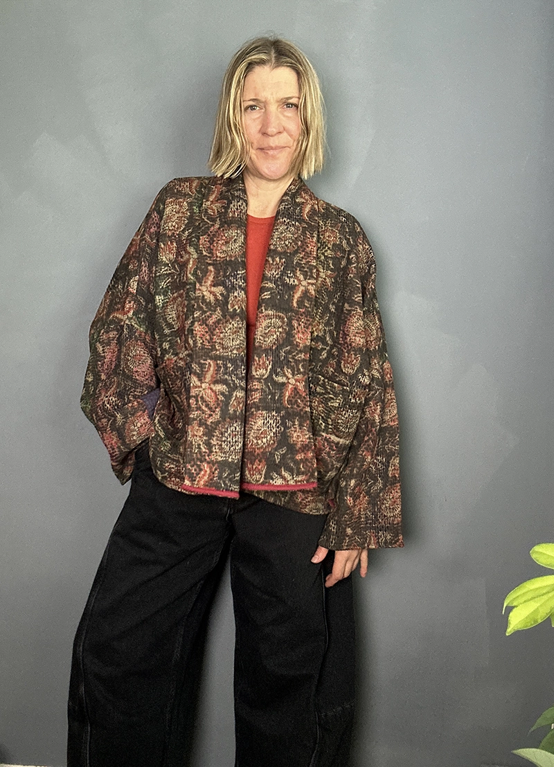 woman wering a dark floral indian kantha jacket