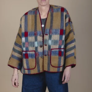 woman with short grey hair wearing camel blanket jacket