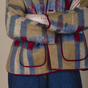 woman with folded arms wearing a blanket jacket