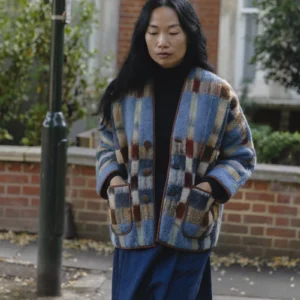 woman with long black hair wearing blue check blanket jacket
