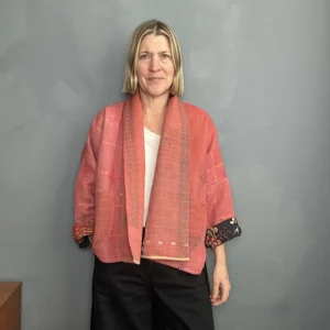 woman wearing a coral pink kantha jacket