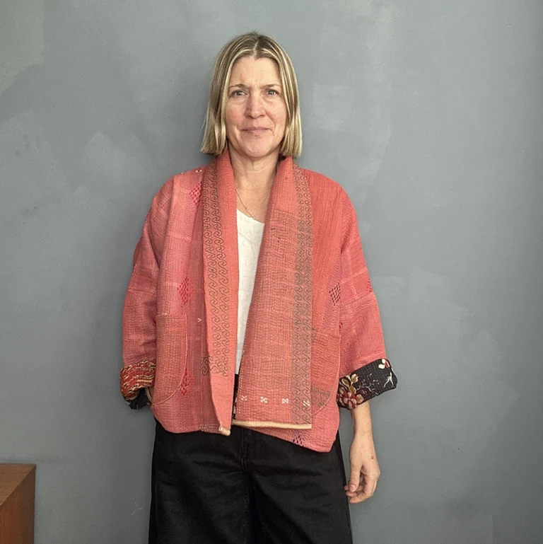 woman wearing a coral pink kantha jacket