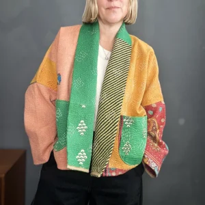 zoom in of woman wearing a rainbow coloured kantha stitched jacket