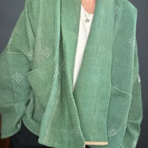 zoom in of woman wearing a green short kantha jacket
