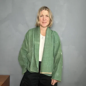 zoom in of woman wearing a fern green short kantha jacket