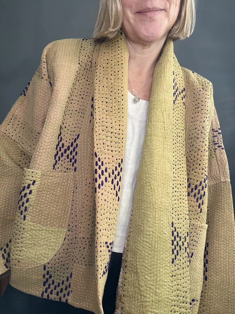 woman wearing a pale yellow kantha stitched jacket