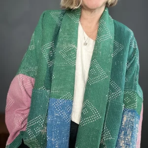zoom in woman wearing a green, blue and pink kantha quilted jacket