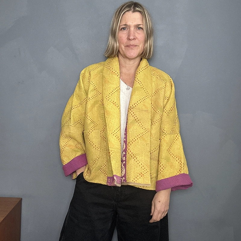 woman wearing a yellow and pink reversible kantha quilted jacket