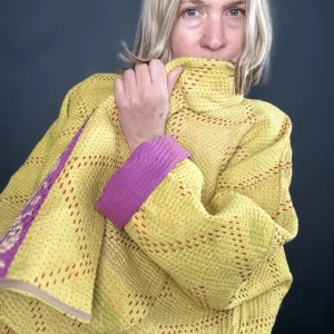 zoom in woman wearing a yellow and pink reversible kantha quilted jacket
